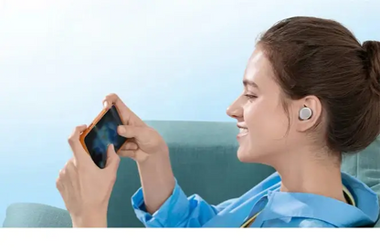Femme écoutant de la musique avec des écouteurs Bluetooth Anker A20i tout en utilisant son smartphone.
